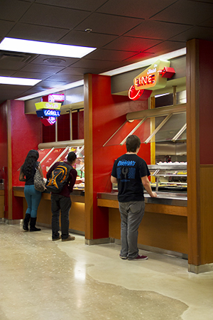 Custom-designed neon signs hang over the grill serving lines.